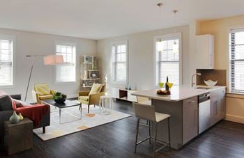 Open concept living, dining and kitchen with hard surface flooring, large windows and prep island
